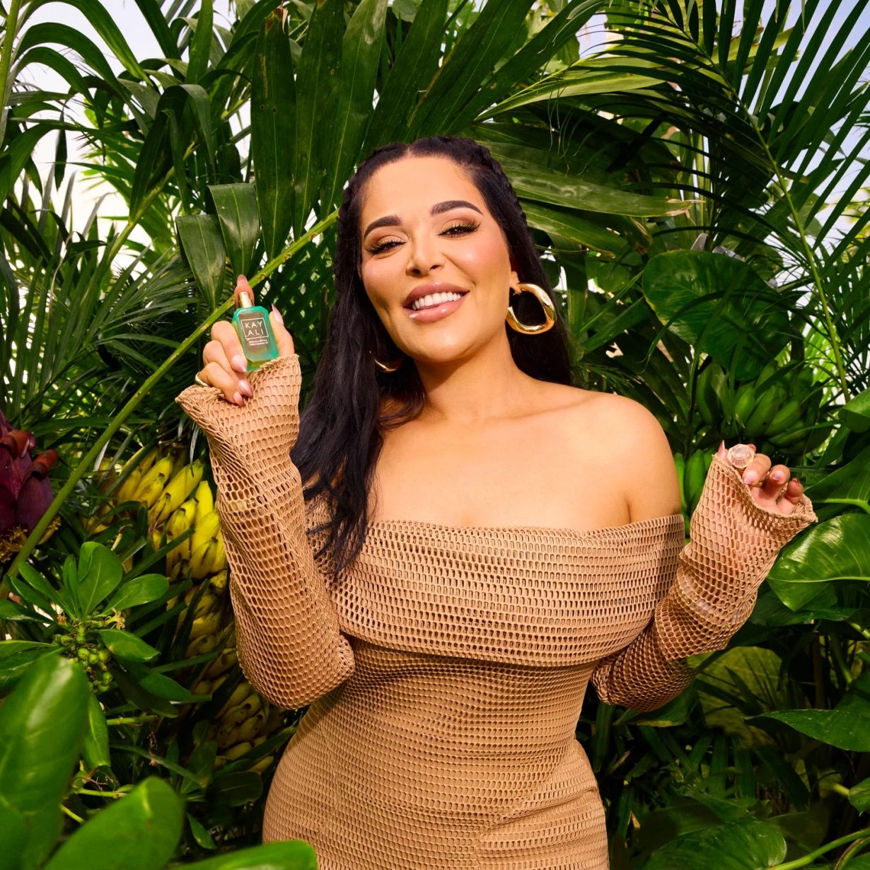 Femme souriante tenant un parfum en jungle