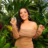 Femme souriante tenant un parfum en jungle